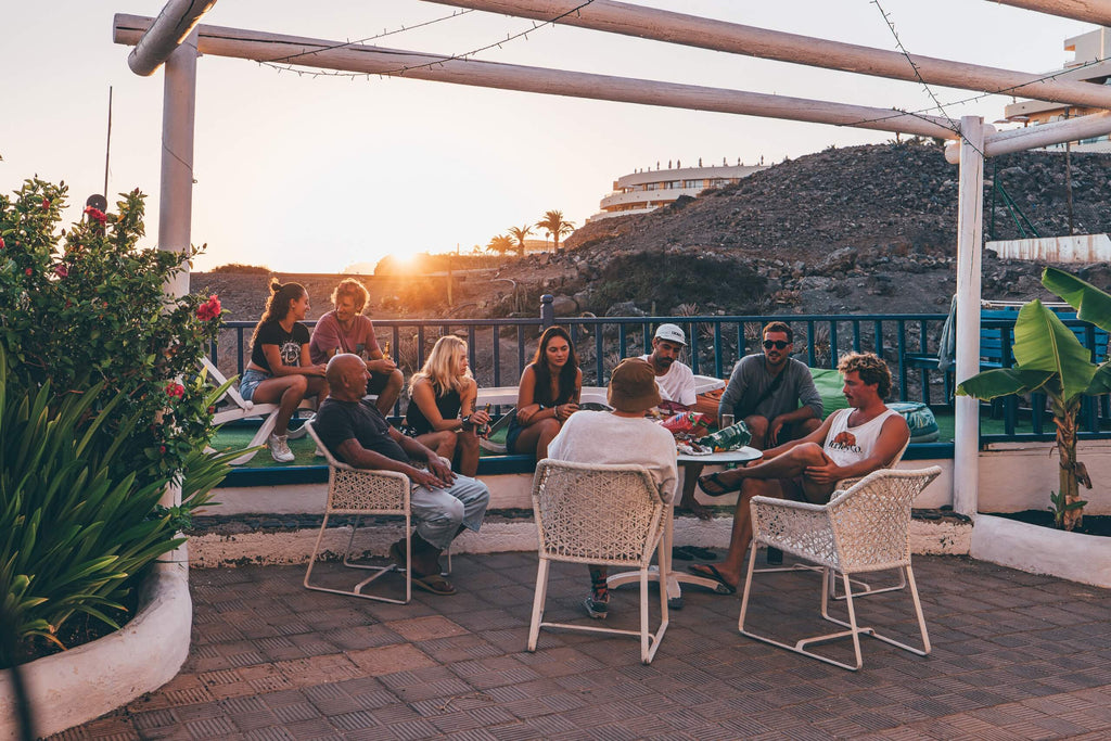 Group of people sitting together outside of the station from Surfers Island enjoying a Barbecue