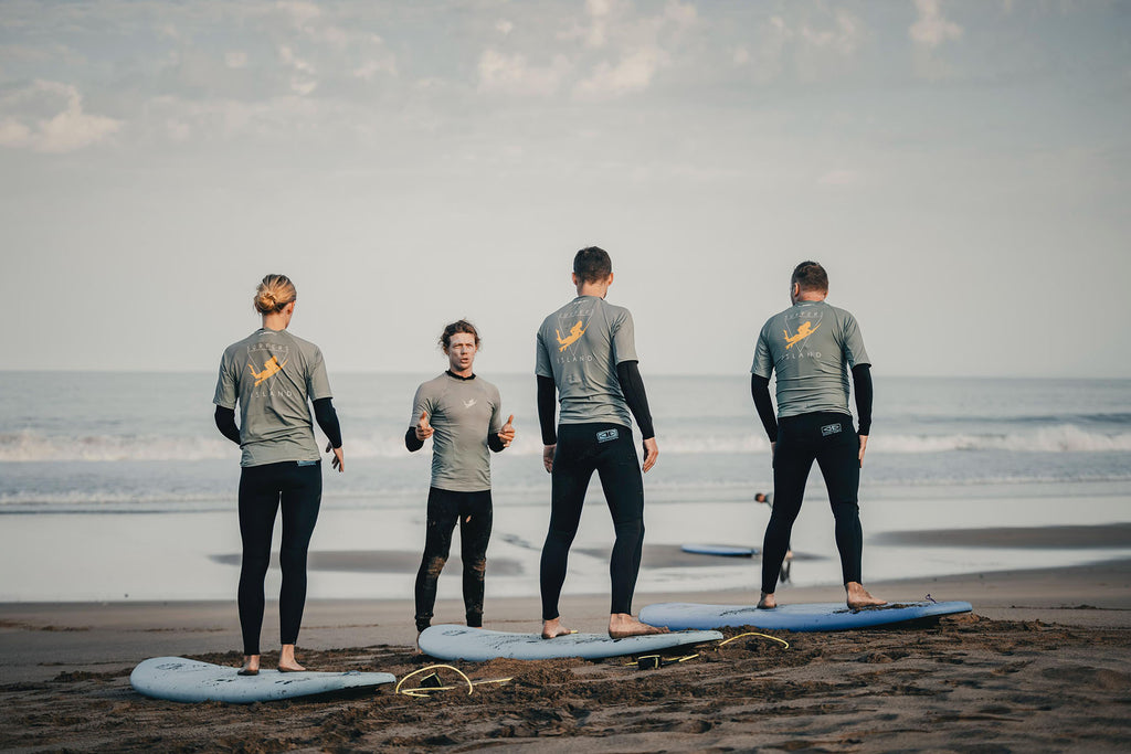 Surf instructor from Surfers Island giving a beach lesson to students with surfboards in La Pared, Fuerteventura