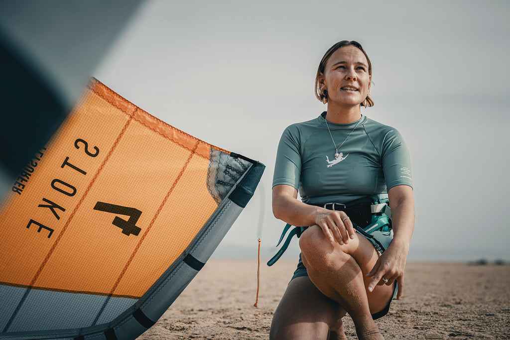 Surfers Island kitesurf instructor kneeling next to kite wing on the beach at Risco del Paso, Fuerteventura