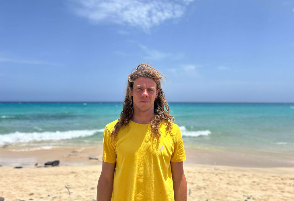 Profile picture of Surf- and Kitesurfinstructor Marcin in front of beach of Morro Jable at the Surfers Island Fuerteventura Station